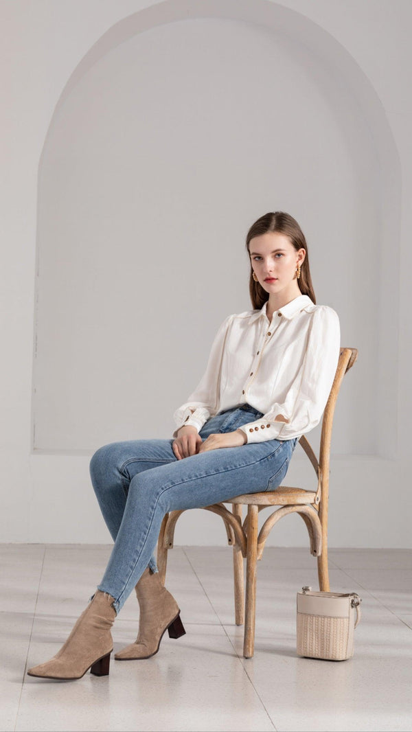  A classic extension of the basic white blouse, this GDS Emilio Blouse is delicately framed by a golden line. Brown buttons create additional contrast to the simplistic appearance of this top.  Available at Harley and Rose